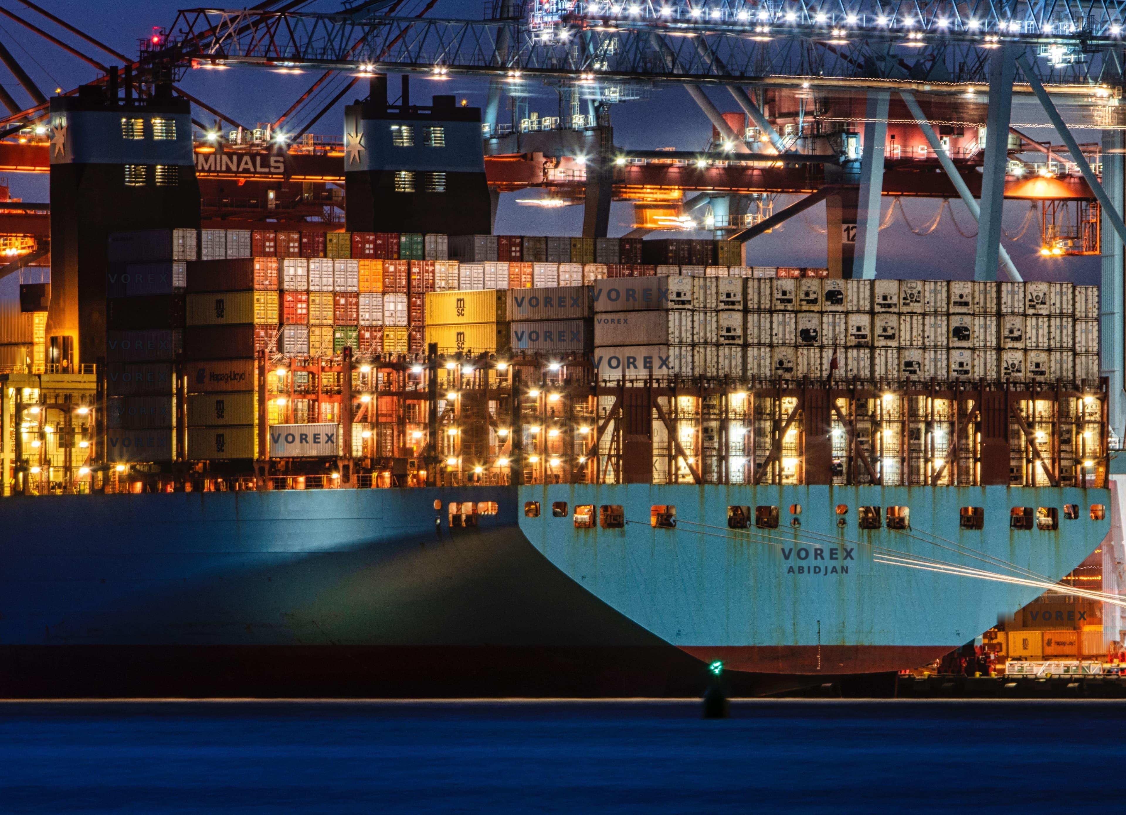 Porte-conteneurs à quai dans un terminal portuaire de nuit